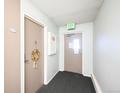 Hallway with apartment doors, carpet, and an exit sign at 650 S Clinton St # 11B, Denver, CO 80247