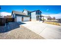 A beautiful two-story home with a spacious driveway and two-car garage showing its curb appeal at 2091 Basil St, Strasburg, CO 80136