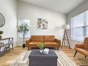 Bright living room features a brown leather sofa, stylish decor, and ample natural light at 2664 S Halifax Ct, Aurora, CO 80013