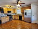 Well-lit kitchen with stainless steel appliances, hardwood floors, and stylish backsplash at 10712 Dayton Way, Commerce City, CO 80640