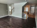 Spacious living room with hardwood floors, staircase, and ample natural light at 10712 Dayton Way, Commerce City, CO 80640