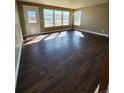 Bright living room featuring hardwood floors, a row of windows, and a glass door at 10712 Dayton Way, Commerce City, CO 80640