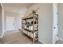 Stylishly decorated entryway with light wood floors and a wooden shelf holding decorative items at 798 Sawdust Dr, Brighton, CO 80601