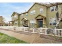 Inviting townhome with green siding, white picket fence, and a covered front porch at 3578 Tranquility Trl, Castle Rock, CO 80109