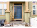 Close-up of a blue front door with rocking chair on a covered front porch at 3578 Tranquility Trl, Castle Rock, CO 80109