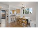 Bright and airy dining area featuring modern lighting, hardwood floors, and an adjacent view of the kitchen at 3379 Krameria St, Denver, CO 80207