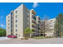 Spacious exterior view of the apartment building showing balconies and landscaping under a clear blue sky at 13952 E Marina Dr # 509, Aurora, CO 80014