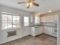 Bright eat-in kitchen featuring white cabinets and a window overlooking the backyard at 9135 W Maplewood Ave, Littleton, CO 80123