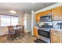 Cozy kitchen featuring wood floors, oak cabinets and stainless steel oven at 5106 Eagle Ct, Denver, CO 80239