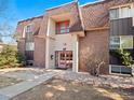Brick apartment building featuring a unique roof line, manicured landscaping, and inviting entrance at 7755 E Quincy Ave # 203A2, Denver, CO 80237