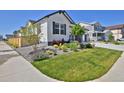 A beautifully landscaped front yard complements this home's modern exterior, plus lush green lawn and mature landscaping at 1160 Spencer Pl, Erie, CO 80026