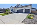 Bright exterior view showcasing a two-car garage, modern design, and landscaped front yard with drought resistant stone at 1160 Spencer Pl, Erie, CO 80026