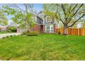 Charming two-story home with a well-maintained lawn, mature trees, brick accents, and a welcoming presence at 1101 Ridgeview Cir, Broomfield, CO 80020