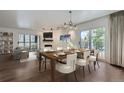 Dining room with a table set for six, views of the balcony, and an open view to the living room at 800 Pearl St # 204, Denver, CO 80203