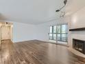 Open living room with hardwood floors, sliding glass doors to the balcony, and a fireplace at 800 Pearl St # 204, Denver, CO 80203