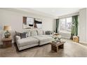 Bright living room with a sectional sofa, large window, and herringbone floors at 1074 Knox Ct, Denver, CO 80204