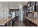 Modern kitchen with dark cabinetry and granite countertops at 21589 E Union Pl, Aurora, CO 80015