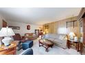 Spacious living room featuring comfortable furnishings, wood paneling, and a stylish glass coffee table at 14157 E 26Th Ave, Aurora, CO 80011