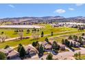 A high aerial view shows a luxury home on a golf course near a lake, offering picturesque views at 16611 Red Cliff Cir, Morrison, CO 80465