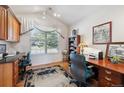 Cozy home office with a large window providing ample natural light, complemented by built-in shelves at 16611 Red Cliff Cir, Morrison, CO 80465