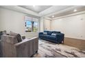 Bright living room featuring a blue sofa and hardwood floors at 9572 Taylor River Cir, Littleton, CO 80125