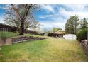 The home's large backyard features a lush lawn, wooden fence, and ample space at 3961 S Uravan St, Aurora, CO 80013