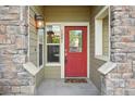 A red door with stone accents and a small porch provides a welcoming entrance at 5800 Tower Rd # 1201, Denver, CO 80249