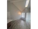 Bright living room with vaulted ceiling, skylight, hardwood floors, and neutral paint at 4876 E Kentucky Ave # F, Denver, CO 80246