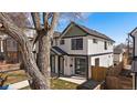 Charming two-story duplex featuring white siding, black trim, green accents, and a well-maintained lawn at 2432 Ames St, Edgewater, CO 80214