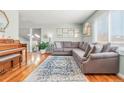 Comfortable living room with a large gray sectional sofa, hardwood floors, a piano, and bright natural light at 15876 E Flora Pl, Aurora, CO 80013