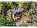 Aerial view of home with a stone chimney, wooden deck, and lush surroundings at 55 Two Moon Rd, Idaho Springs, CO 80452