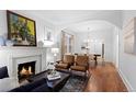 Inviting living room featuring a fireplace, hardwood floors, and an open layout leading to the dining area at 1245 Garfield St, Denver, CO 80206