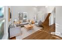 Bright living room showcases hardwood floors, neutral furniture, and a staircase with natural light at 10020 Strathfield Ln, Highlands Ranch, CO 80126