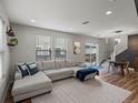 Inviting living room featuring a plush sectional sofa, large windows, and access to an outdoor deck and stairs at 14823 W 70Th Dr # A, Arvada, CO 80007