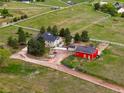 Expansive acreage with lovely green home and red barn surrounded by white fencing at 41504 Vista Ridge, Parker, CO 80138
