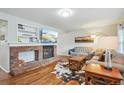 Inviting living room featuring a brick fireplace, built-in shelving, hardwood floors, and comfortable sofas at 6880 E Appleton Cir, Centennial, CO 80112
