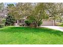 Charming home with a well-manicured lawn, mature trees, and a welcoming front entrance at 1896 S Marshall Cir, Lakewood, CO 80232