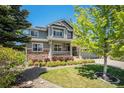 Beautiful two-story home with stone accents, a covered porch, and lush landscaping at 26004 E Elmhurst Pl, Aurora, CO 80016