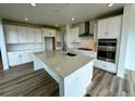Bright kitchen featuring an island with countertop, white cabinets and modern appliances at 13358 Blue Amber Ct, Parker, CO 80134