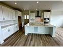Bright kitchen featuring an island with countertop, white cabinets and modern appliances at 13358 Blue Amber Ct, Parker, CO 80134