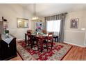 Cozy dining room featuring a wood table, elegant rug, and soft natural lighting at 1427 Deerwood Dr, Longmont, CO 80504