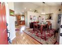 Open dining room with wood floors, stylish rug, and an open view of the updated kitchen at 1427 Deerwood Dr, Longmont, CO 80504