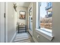 Bright entryway with a coat rack, decorative mirror, sleek shoe rack, and large window for natural light at 2790 W 25Th Ave # 6, Denver, CO 80211