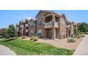 Multi-story condo building shows stone accents, private balconies, and well-manicured lawn at 7440 S Blackhawk St # 14-208, Englewood, CO 80112