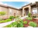 Charming entrance adorned with stone accents, decorative plants and mulch, and a pathway at 12467 Topaz Vista Way, Castle Pines, CO 80108