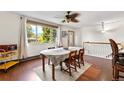 Light-filled dining room with hardwood floors and a view of the outdoor greenery from a large window at 1430 Mount Evans Dr, Longmont, CO 80504