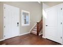 Welcoming foyer with hardwood floors, staircase, and natural light from the window at 42395 Forest Oaks Dr, Elizabeth, CO 80107