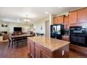 Open-concept kitchen featuring granite countertops, stainless steel appliances, and hardwood floors at 42395 Forest Oaks Dr, Elizabeth, CO 80107