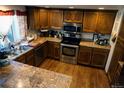 Well-lit kitchen with stainless steel appliances and wood cabinets and flooring at 7920 E Phillips Cir, Centennial, CO 80112
