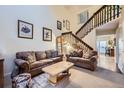 Spacious living room with cozy seating, stairway, and natural light, perfect for relaxation at 7920 E Phillips Cir, Centennial, CO 80112